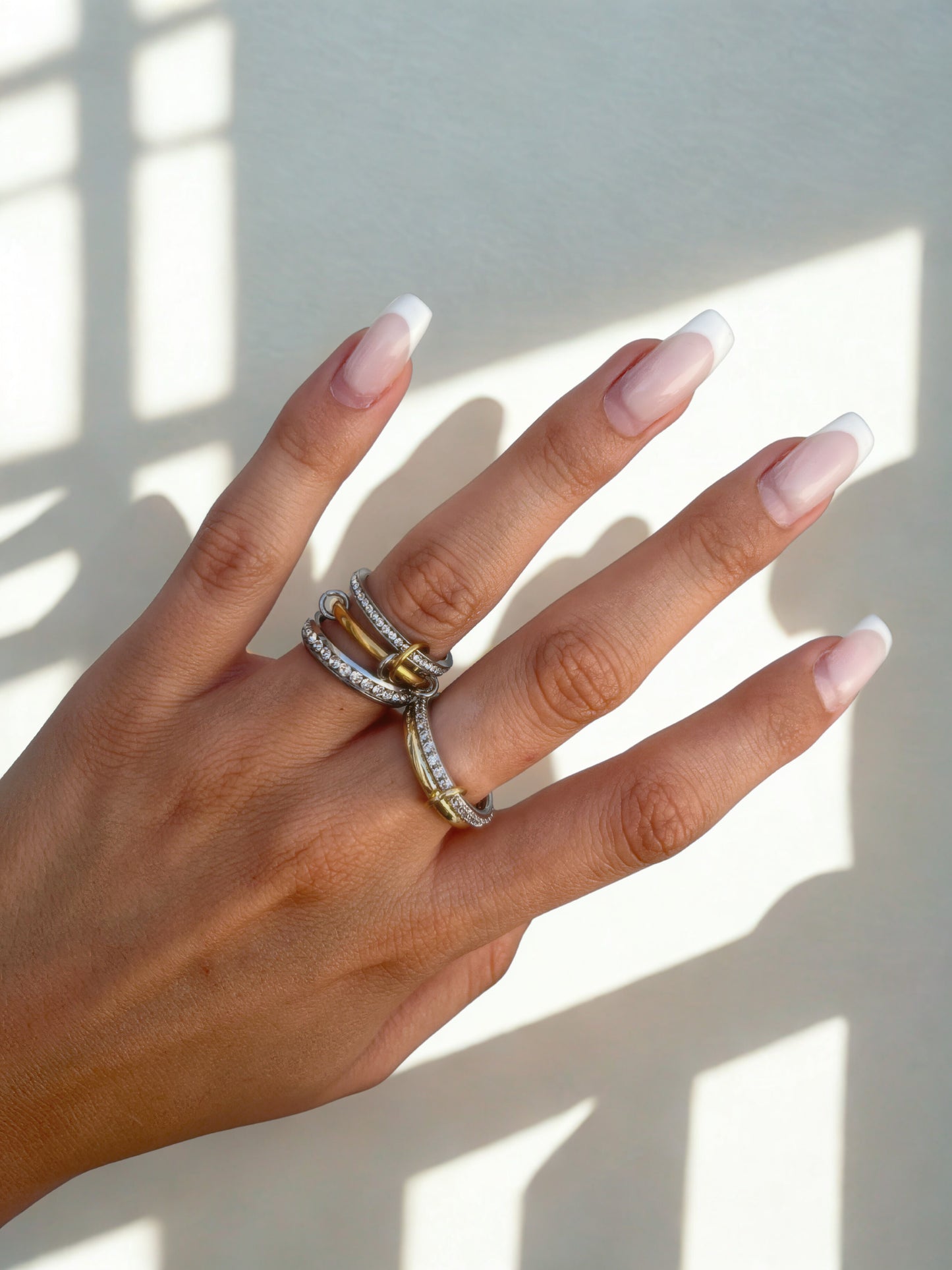 Gold, silver, and pavé titanium rings stacked on hand – waterproof jewelry