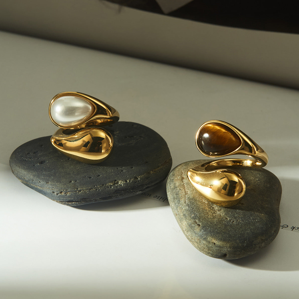 Minimalist shot of gold statement rings on neutral linen