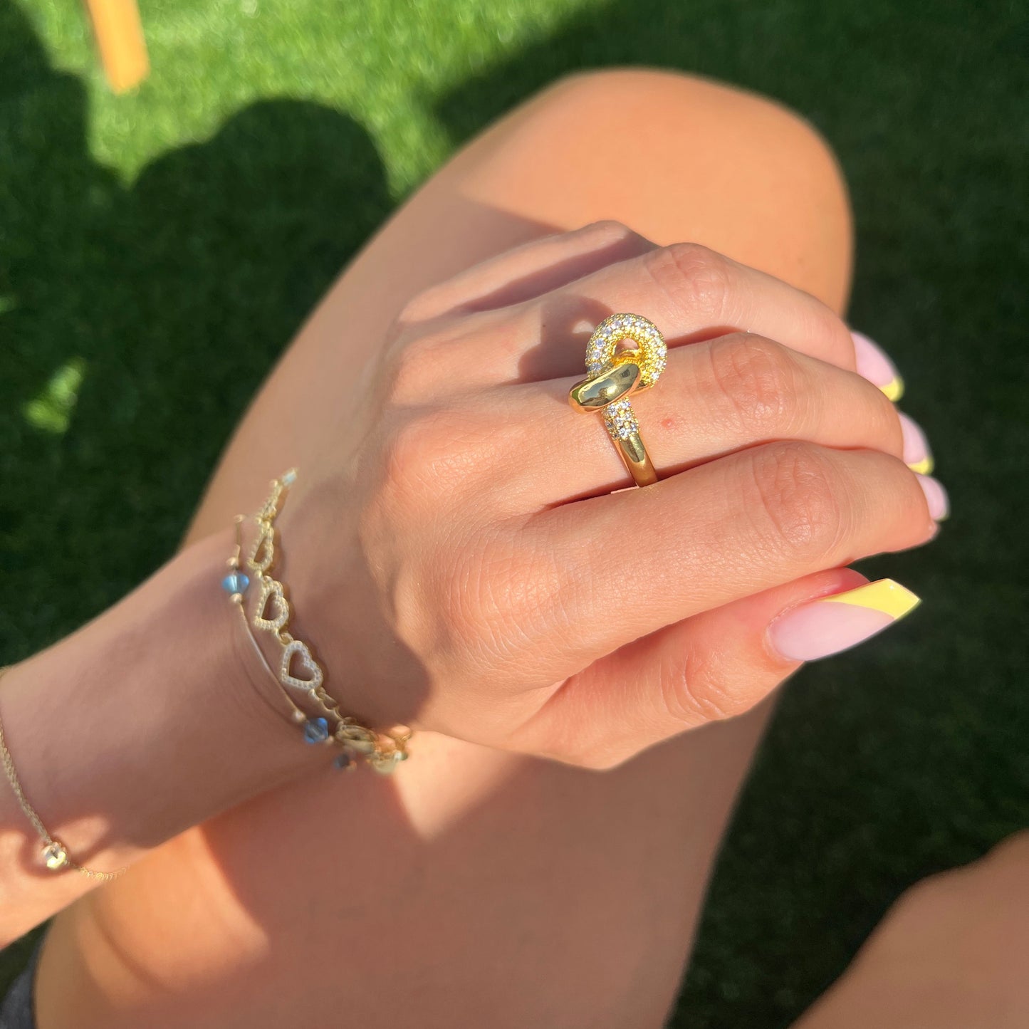 Hand holding Aurora Ring with golden sparkle in sunlight