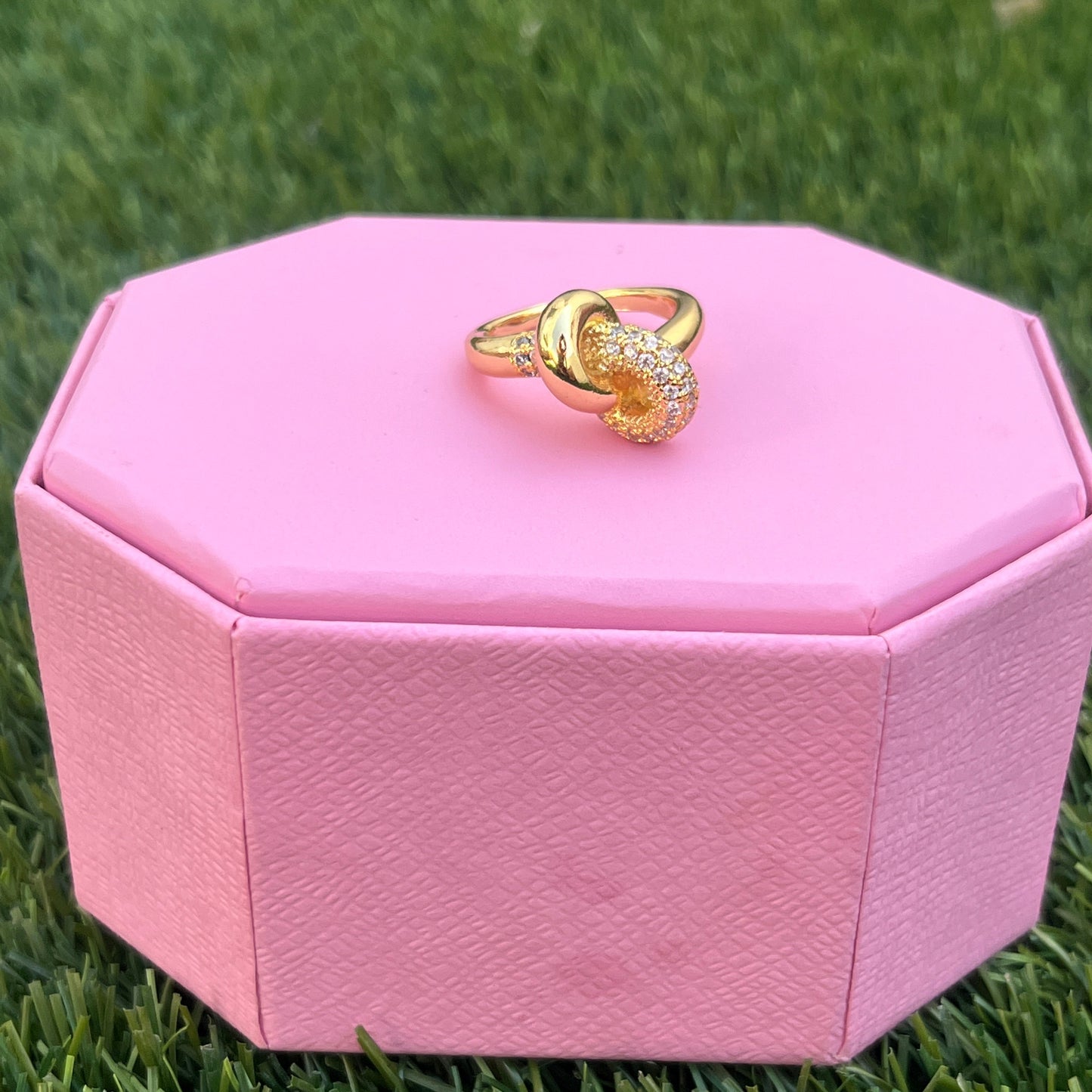 Statement ring displayed on pink box, top view
