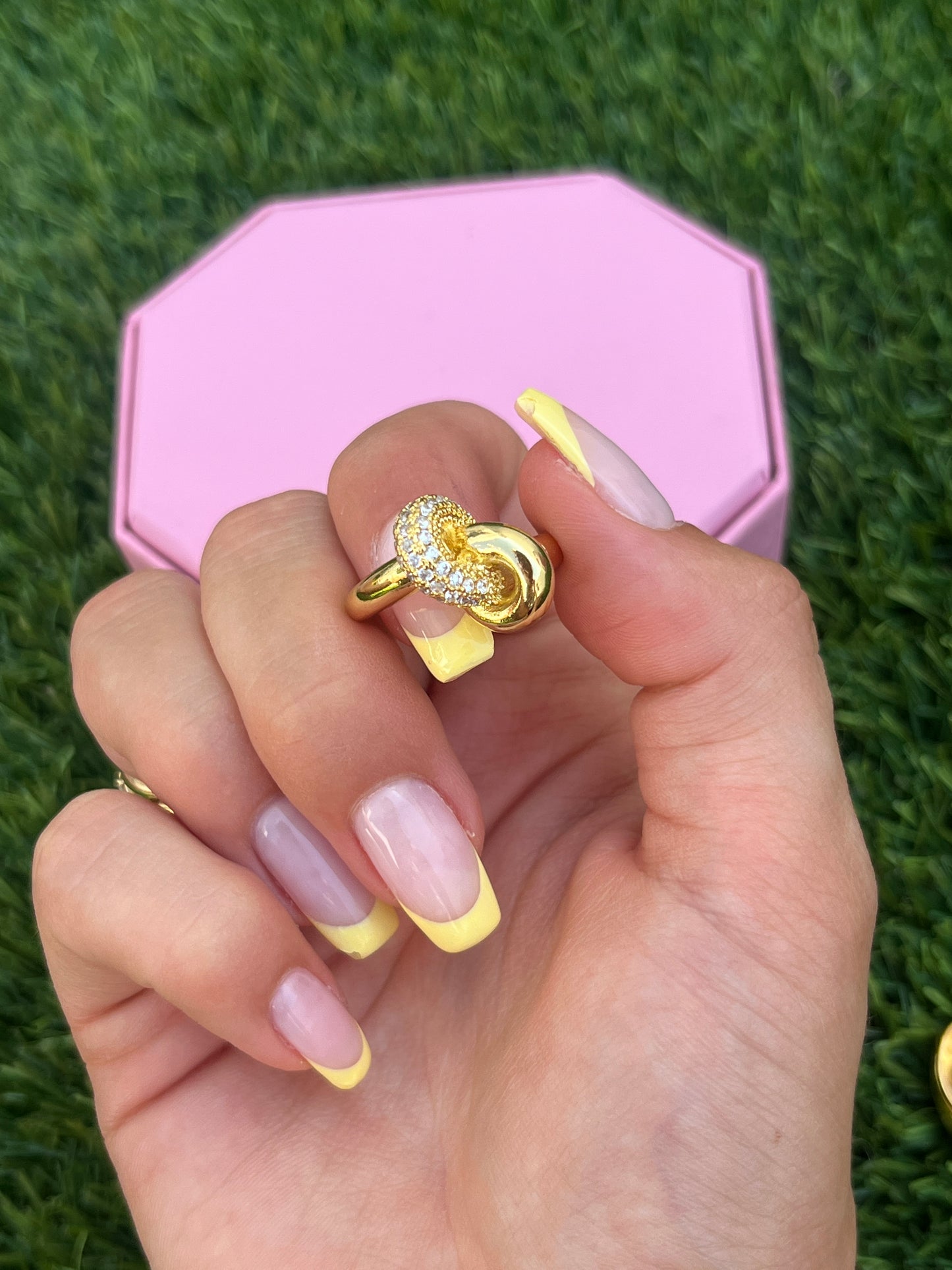 Close-up of 18K gold-plated Aurora Ring held between fingers