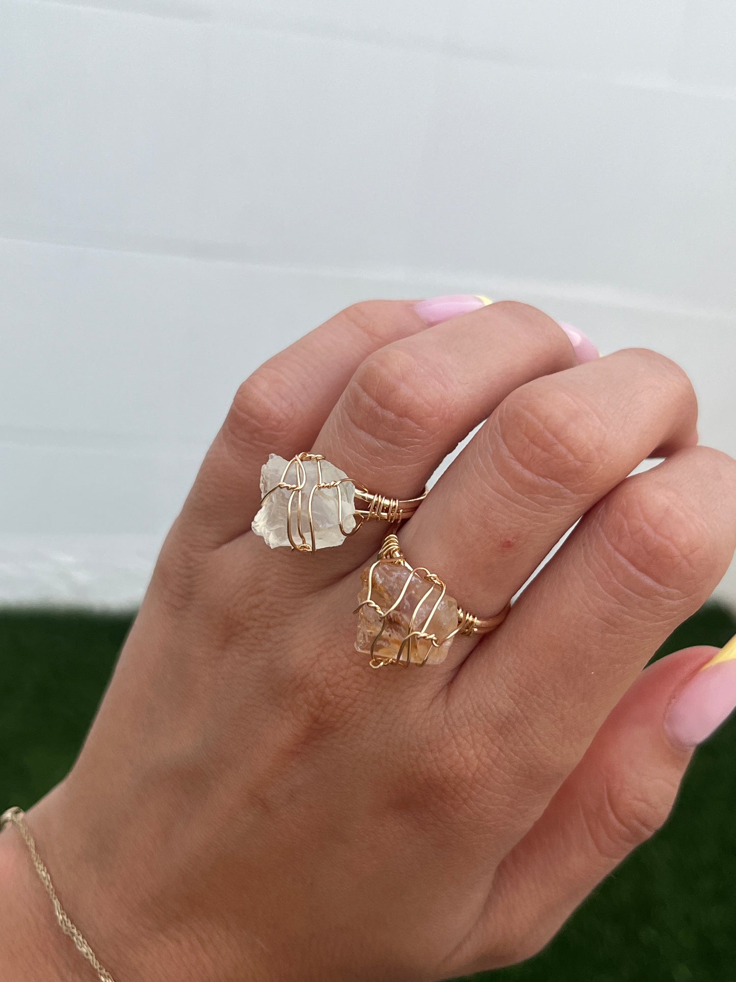 Close-up of Miel Ring on two fingers in natural light