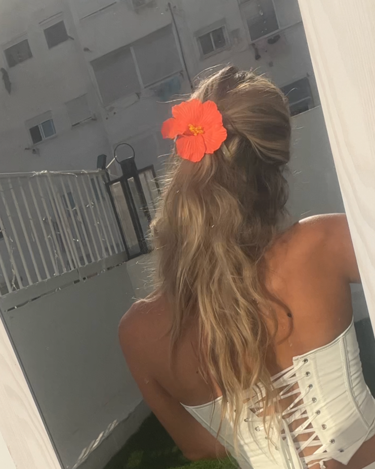 Bold orange flower hair clip with sleek ponytail – Luzé style
