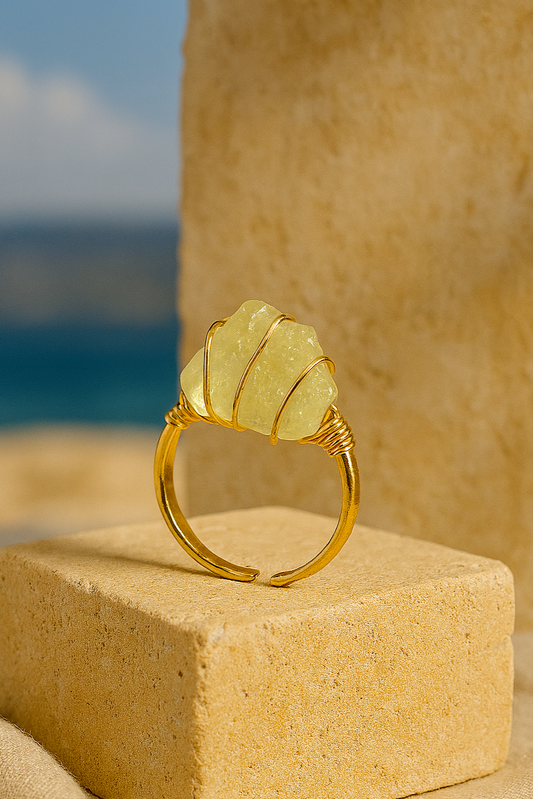 Gold Sol Ring displayed on stone pedestal with blue sky background