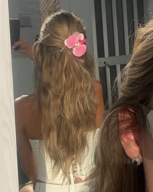 Pink flower hair clip styled in long blonde waves – Luzé summer hair