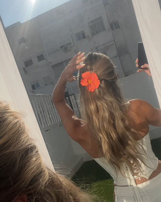 Bright orange flower clip styled in long blonde hair – Luzé accessory